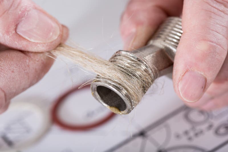 plumber-putting-hemp-fibers-thread-closeup-61335192.jpg